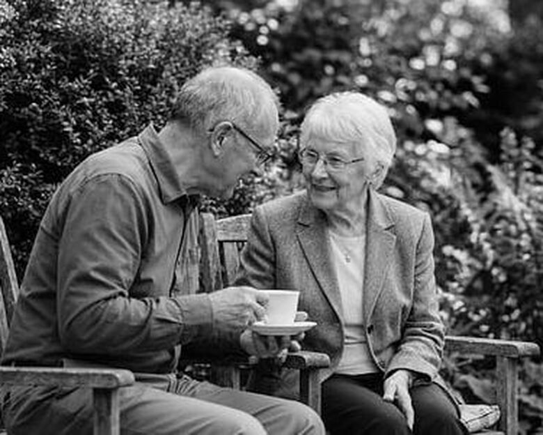 en baby i dåbskjole sidder ved sin mor i kirken