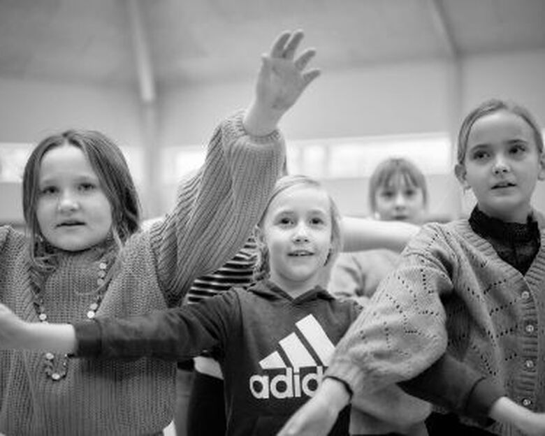 Børn omkring 8 års alderen laver fagter til sang