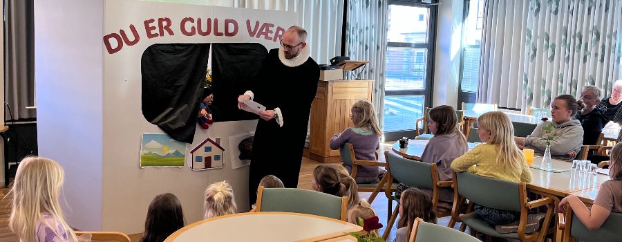 børn og unge Præst fortæller for børn foran et dukketeater